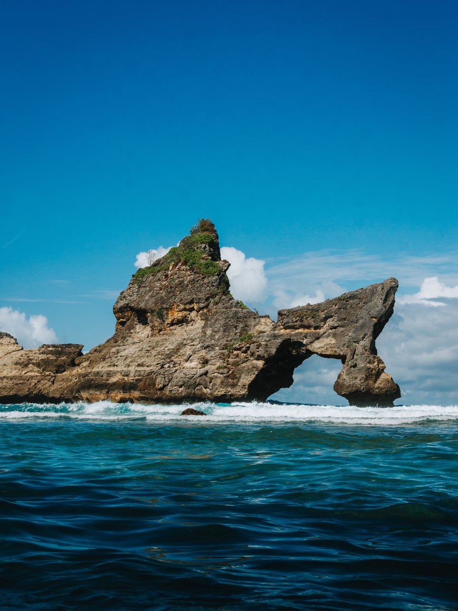 The rock arch standing off Atuh Beach