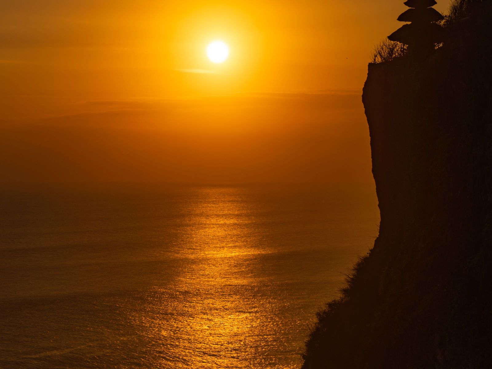 The sun setting beside the Uluwatu cliff