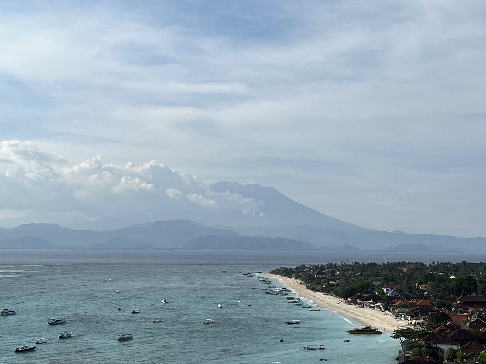 Boats moored off Nusa Lembongan, Bali mountains beyond